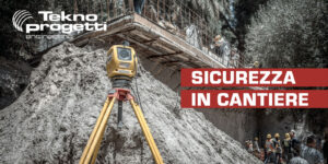 Strumento di rilevazione topografica su treppiede in un cantiere di scavo con operai al lavoro in quota.